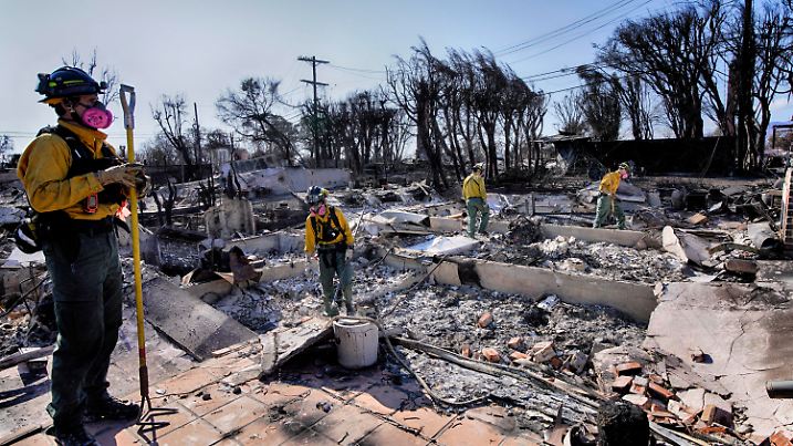 17.01.2025, USA, Los Angeles: Lt. Matt Phillips, links, vom Kitsap County Firefighting Strike Team aus Bainbridge Island, Wash, leitet seine Mannschaft bei der Überprüfung von Häusern auf strukturelle Probleme nach dem Palisades Fire im Pacific Palisades-Viertel von Los Angeles Foto: Richard Vogel/AP/dpa +++ dpa-Bildfunk +++