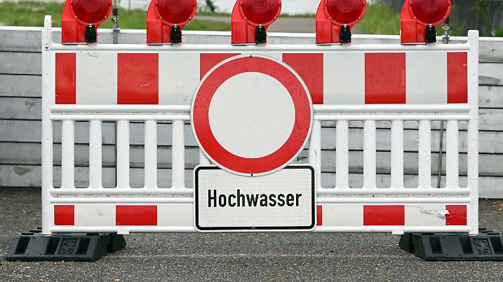 14.07.2021, Baden-Württemberg, Karlsruhe: In der Nähe des Rheinpegel Maxau steht eine Barriere auf der ein Schild mit der Aufschrift Hochwasser angebracht ist. Wegen Hochwasser wurde die Schifffahrt bei Karlsruhe eingestellt. Foto: Uli Deck/dpa +++ dpa-Bildfunk +++
