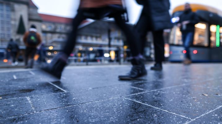 ARCHIV - 19.12.2022, Sachsen, Leipzig: Passanten gehen über die feuchte Haltestelle vor dem Hauptbahnhof. Der für heute vorhergesagte Regen fällt auf gefrorenen Boden und kann für gefährliches Glatteis sorgen. Für Teile aller Bundesländer galten am Morgen deswegen Unwetterwarnungen des Deutschen Wetterdienstes (DWD). (zu dpa: «Glättewarnung für Sachsen und Thüringen») Foto: Jan Woitas/dpa +++ dpa-Bildfunk +++