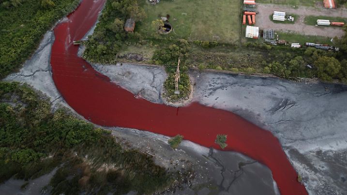 06.02.2025, Argentinien, Buenos Aires: Eine Luftaufnahme zeigt den «Sarandí»-Fluss in einem Industriegebiet am Rande von Buenos Aires, dessen Wasser sich intensiv rot verfärbt hat. Anwohner vermuten, dass unbekannte Schadstoffe für die auffällige Färbung verantwortlich sind. Das Umweltministerium hat Wasserproben entnommen, um die Ursache der Verfärbung zu ermitteln Foto: Rodrigo Abd/AP/dpa +++ dpa-Bildfunk +++