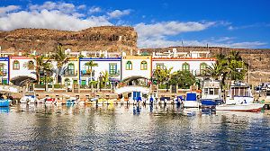 Colorful Canarian style houses and boats in the harbour of Puerto de Mogan, Gran Canaria.