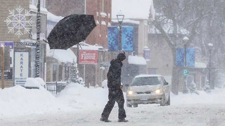 250217 -- MISSISSAUGA, Feb. 17, 2025 -- A pedestrian s umbrella is broken and blown away as he crosses a street in Mississauga, the Greater Toronto Area, Canada, on Feb. 16, 2025. Photo by /Xinhua CANADA-THE GREATER TORONTO AREA-WINTER STORM ZouxZheng PUBLICATIONxNOTxINxCHN