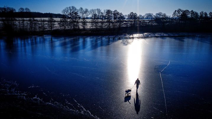dpatopbilder - 18.02.2025, Mecklenburg-Vorpommern, Vietlübbe: Ein Eisangler ist mit einem Schlitten auf dem zugefrorenen Vietlübber See unterwegs. (Luftaufnahme mit einer Drohne). Mit frostigen Temperaturen um minus zehn Grad und viel Sonnenschein zeigt sich das Winterwetter in Norddeutschland von seiner freundlichen Seite. Foto: Jens Büttner/dpa +++ dpa-Bildfunk +++