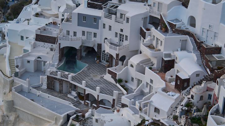 ARCHIV - 04.02.2025, Griechenland, Santorini: Ein leerer Swimmingpool ist zwischen Häusern auf den Klippen in Oia auf der erdbebengeschädigten Insel Santorini zu sehen. (zu dpa: «In drei Wochen 21.500 Beben auf Santorini») Foto: Petros Giannakouris/AP/dpa +++ dpa-Bildfunk +++