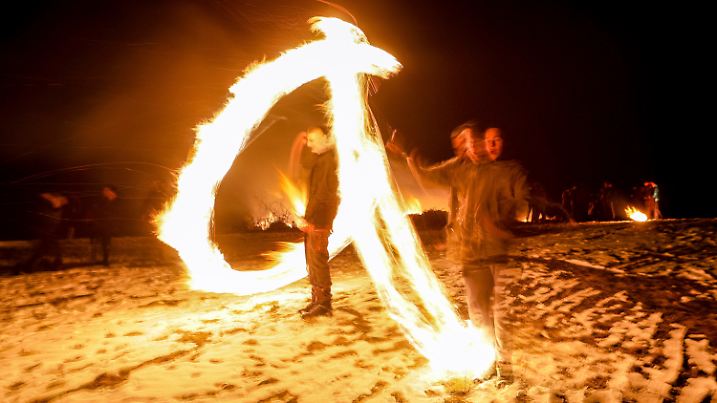 dpatopbilder - 23.02.2025, Bulgarien, Lozen: Ein Bild mit Langzeitbelichtung zeigt einen Jungen, der mit Feuerkugeln spielt, während Ritualen zur Feier von Mesni Zagovezni (Fastnacht) im Dorf Lozen in der Nähe der Hauptstadt Sofia, in dem Glauben, dass die Feuertradition die bösen Geister vertreibt und den Frühling willkommen heißt. Foto: Valentina Petrova/AP/dpa +++ dpa-Bildfunk +++
