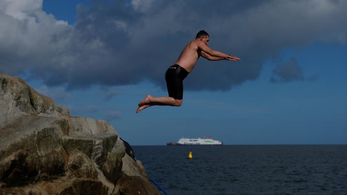 A man jumps into the water in cold weather from a rocky outcrop called the Forty Foot, in Sandycove, Ireland, February 27, 2025. REUTERS/Clodagh Kilcoyne