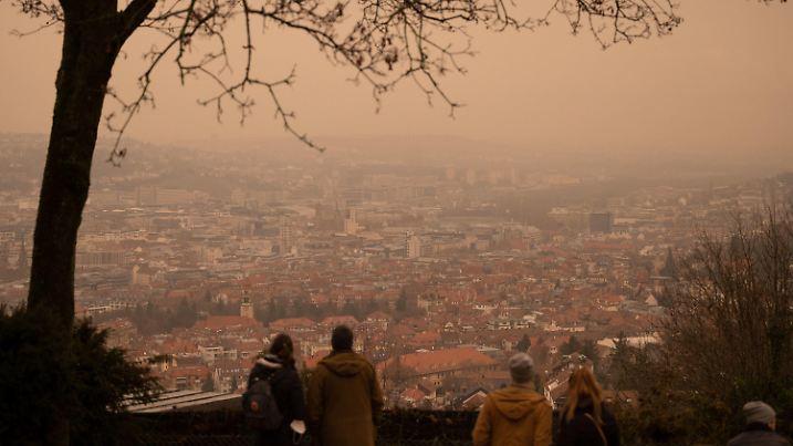 ARCHIV - 06.02.2021, Baden-Württemberg, Stuttgart: Gelb-rötlich erscheint der Himmel über der Innenstadt von einem Aussichtspunkt aus, weil in der Luft Saharastaub sein soll. (zu dpa: «Mildes Wetter bringt Saharastaub nach Deutschland») Foto: Marijan Murat/dpa +++ dpa-Bildfunk +++
