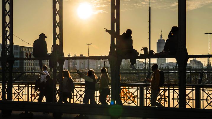 Treffpunkt Hackerbrücke, junge Menschen sitzen entspannt in den Brückenbögen, genießen das Frühlingswetter, München, März 2025 Deutschland, München, März 2025, Treffpunkt Hackerbrücke, junge Menschen sitzen entspannt in den Brückenbögen, genießen das Frühlingswetter in den schmiedeeisernen Bögen über den Gleisen, eine Stunde vor Sonnenuntergang zeigt das Thermometer 10 Grad, die Hackerbrücke ist als abendlicher Treffpunkt in den letzten Jahren populär geworden, eine andere Gruppe junger Leute kommt gerade von der S-Bahn, Frühling, schönes Wetter, Bayern, *** Hackerbrücke meeting point, young people sitting relaxed in the bridge arches, enjoying the spring weather, Munich, March 2025 Germany, Munich, March 2025, Hackerbrü