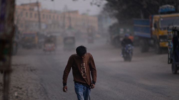 08.02.2025, Bangladesch, Dhaka: Ein Mann bedeckt sein Gesicht mit seinem T-Shirt, um sich vor dem Smog zu schützen. Foto: Mahmud Hossain Opu/AP/dpa +++ dpa-Bildfunk +++