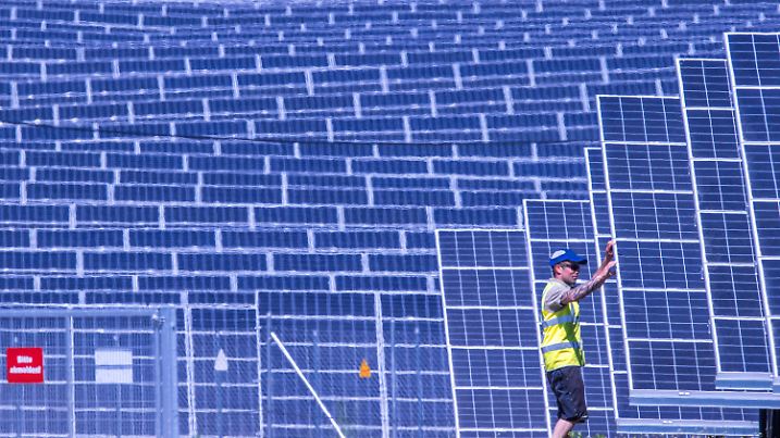 ARCHIV - 31.05.2021, Mecklenburg-Vorpommern, Gaarz: Ein Monteur prüft den Kabelanschluss an einem Solarpanel im Photovoltaik-Park des Unternehmens Enerparc. Die Unternehmen Enerparc und die Deutsche Bahn haben einen Stromliefervertrag über jährlich 80 Gigawattstunden abgeschlossen. Der Solar-Park auf einer Fläche von rund 91 Hektar soll in den nächsten 30 Jahren Strom für die Bahn liefern. (zu dpa: «Ökostrom für die Bahn: Studie sieht großes Potenzial an Trassen») Foto: Jens Büttner/dpa-Zentralbild/dpa +++ dpa-Bildfunk +++