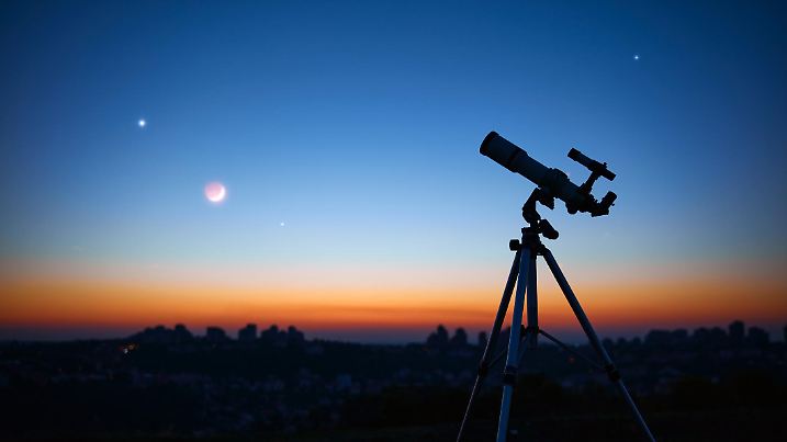 Astronomical telescope under a twilight sky ready for stargazing.