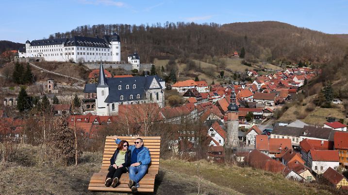 20.03.2025, Sachsen-Anhalt, Stolberg/Harz: Ein Ehepaar aus Thüringen genießt die Sonne vor der Kulisse des Fachwerkstädtchens im Südharz. Dem deutschen Wetterdienst zufolge erwärmt sich die eingeflossene trockene Kontinentalluftmasse unter zunächst noch weiter anhaltendem Hochdruckeinfluss kräftig. Das Wochenende wird warm und windig. Foto: Jan Woitas/dpa +++ dpa-Bildfunk +++