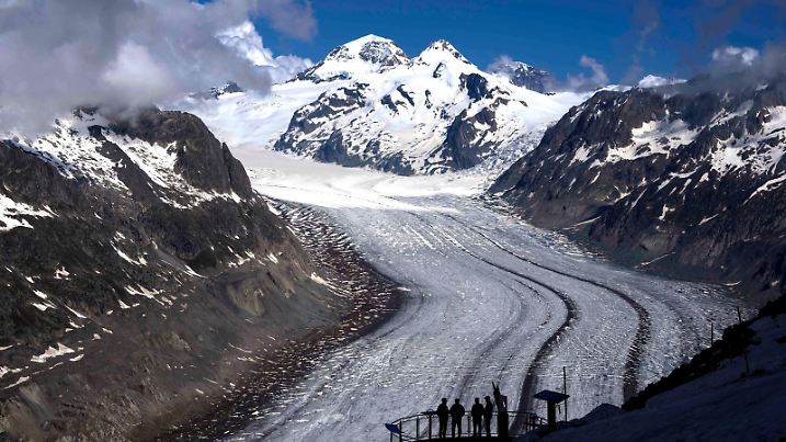 ARCHIV - 14.06.2023, Schweiz, Goms: Menschen genießen die Aussicht auf den Aletschgletscher in der Nähe von Goms. (zu dpa: «Gletscherschwund ist «Frage des Überlebens» für Menschheit») Foto: Matthias Schrader/AP/dpa +++ dpa-Bildfunk +++