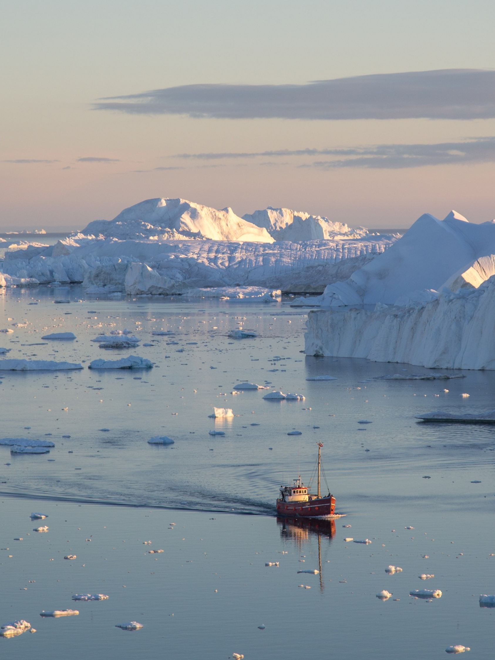 Grönland, eisiger Fjord mit Eisbergen und Fischerboot