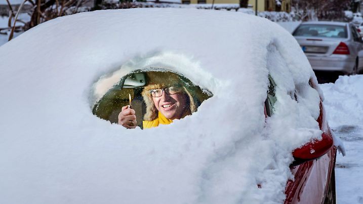 News Bilder des Tages Autofahrer befreit mit Feuerzeug Windschutzscheibe von Schnee, München, Dezember 2023 Deutschland,