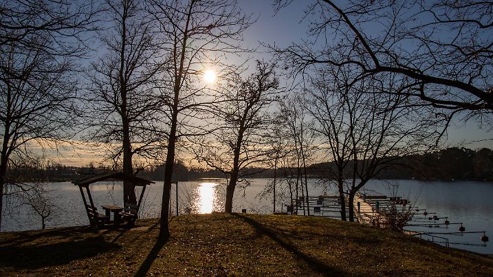 Empty docks in the port of Scharmuetzelsee, Brandenburg, Germany. Reflection in the water. Empty docks in winter under the clear sky at noon.