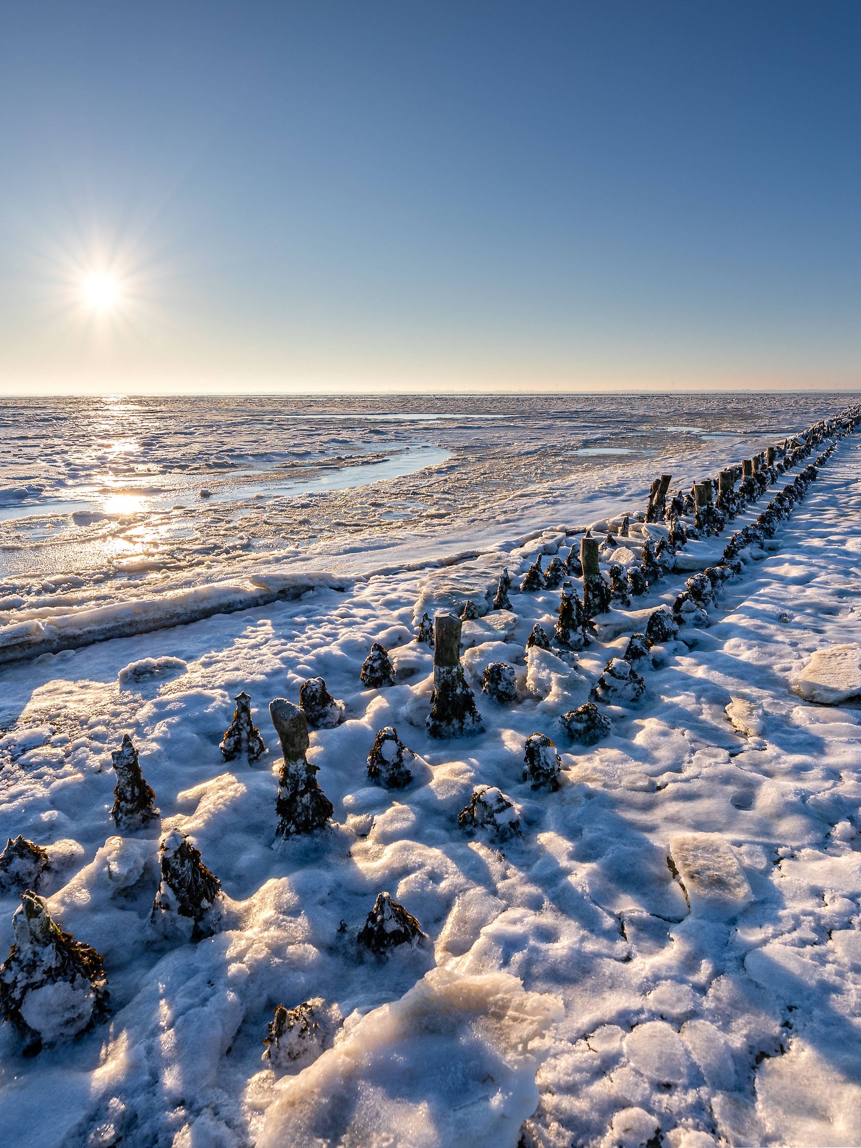 Norderney. 07 FEB 2021. Kalter Winter auf den ostfriesischen Inseln. Eis und Schnee am Ostende von Norderney. Wintersonn