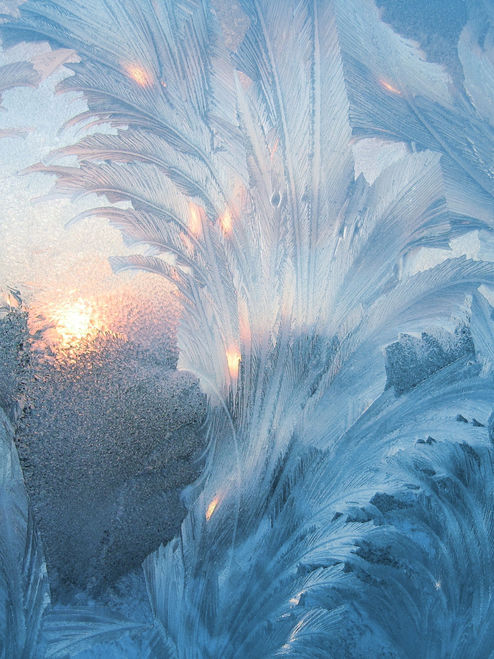 Gefrorene Scheibe bei Kälte mit Eis im Winter mit Sonnenschein im Hintergrund