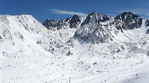 Schneebedeckte Berggipfel unter klarem Himmel in den winterlichen Bergen von Andorra.