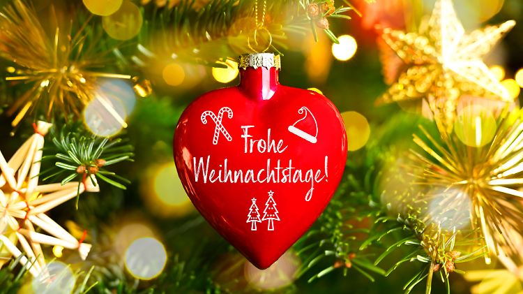 Weihnachtskugel in Form eines Herzens mit Aufschrift Frohe Weihnachtstage hängt an einem Weihnachtsbaum, Fotomontage