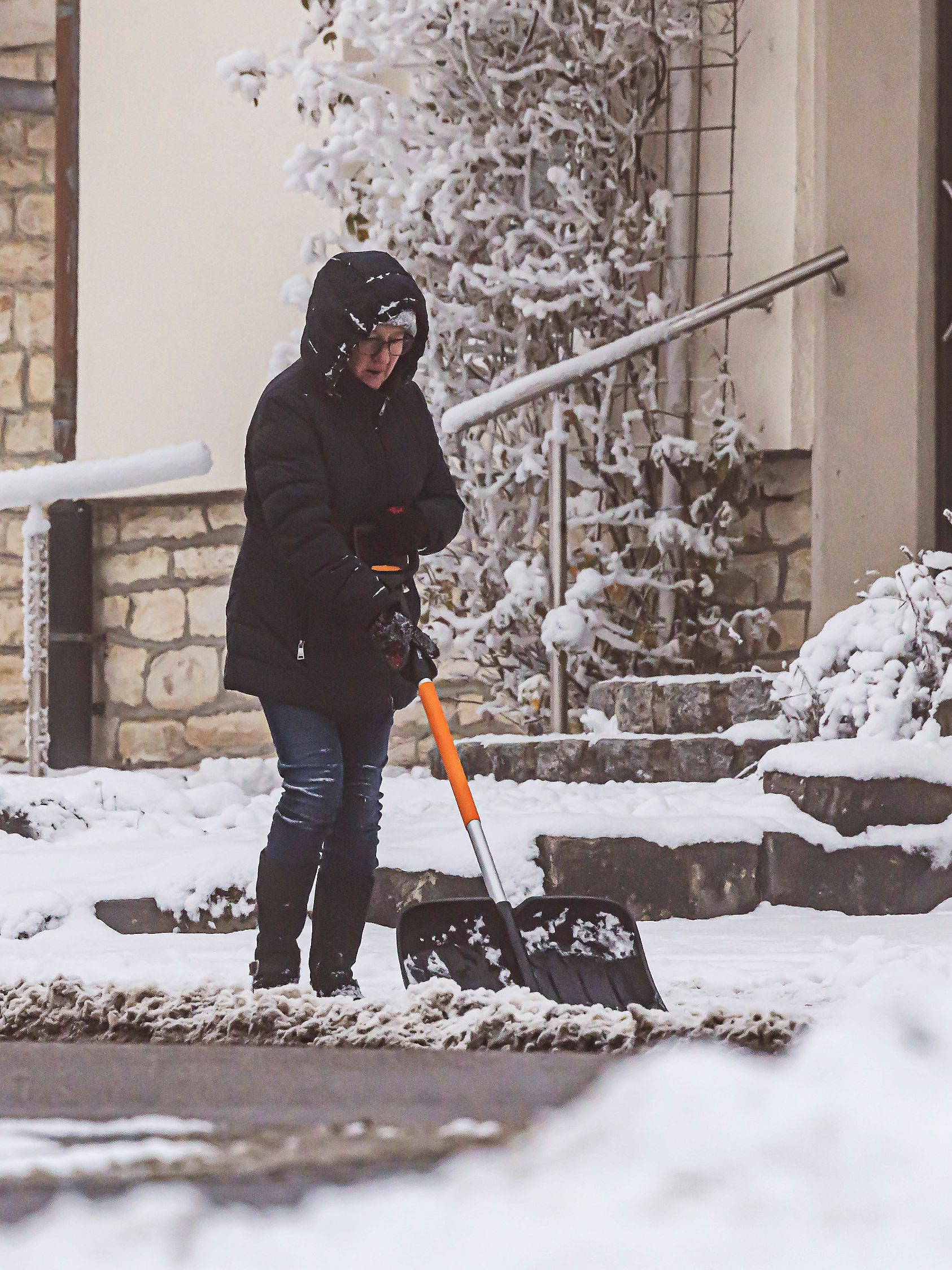 Winter auf der Schwäbischen Alb. Frau beim Schneeschippen. // 26.12.2025, Westerheim, Baden-Württemberg, Deutschland ***
