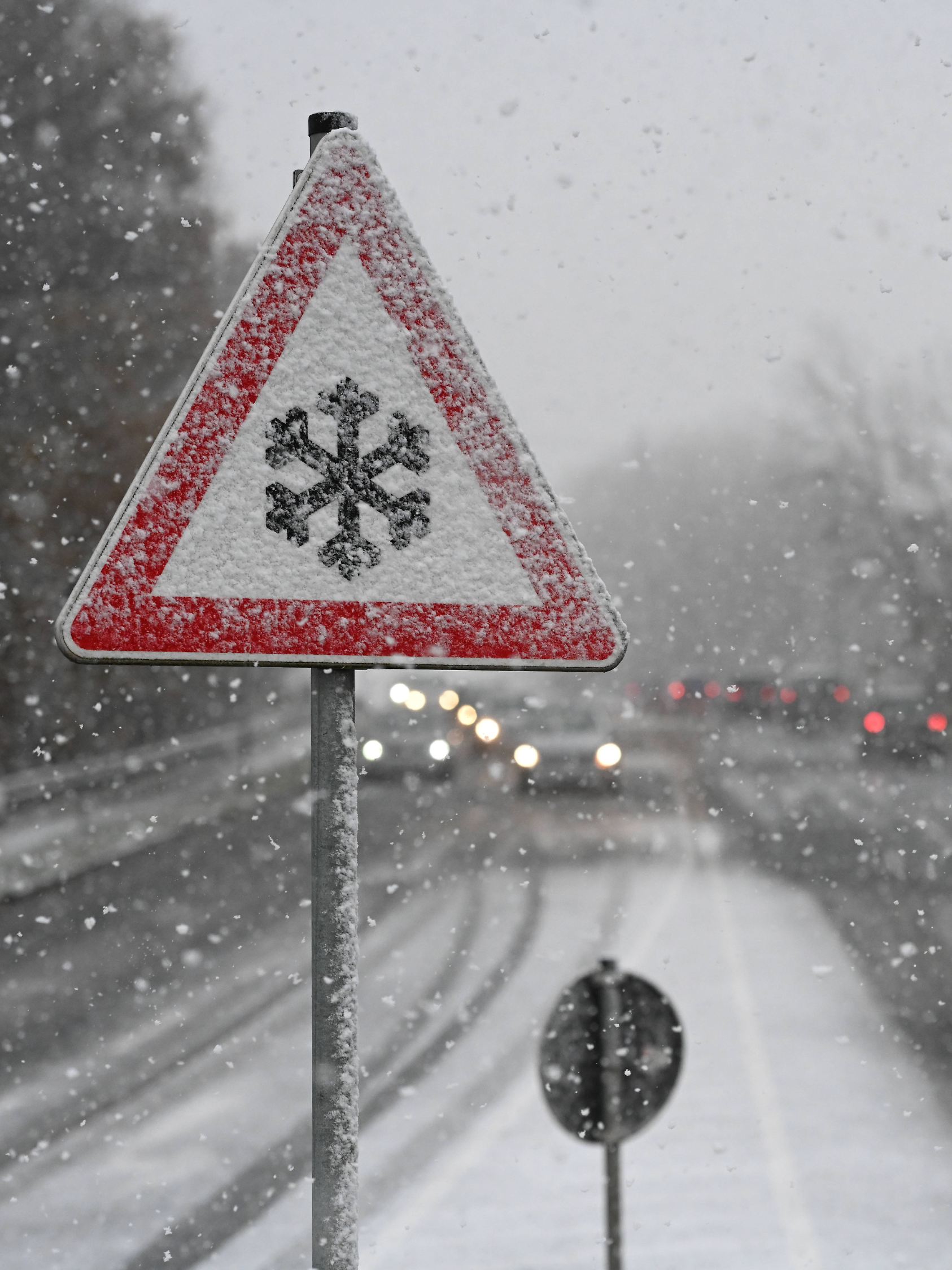 Schneefall in Ostfriesland. Das Verkehrszeichen 101-51 Schnee- oder Eisglätte warnt vor Glätte durch Vereisungen sowie S