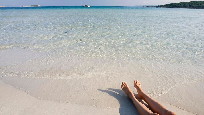 Frauenbeine am Strand Cala Brandinchi Sardinien Italien