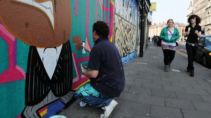Der in Bristol ansässige Graffiti-Künstler Mich spray malt ein Graffiti-Stück im Stadtteil Stokes Croft.