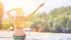 Junge Frau im Bikini beim Sonnen am Steg im Sommer