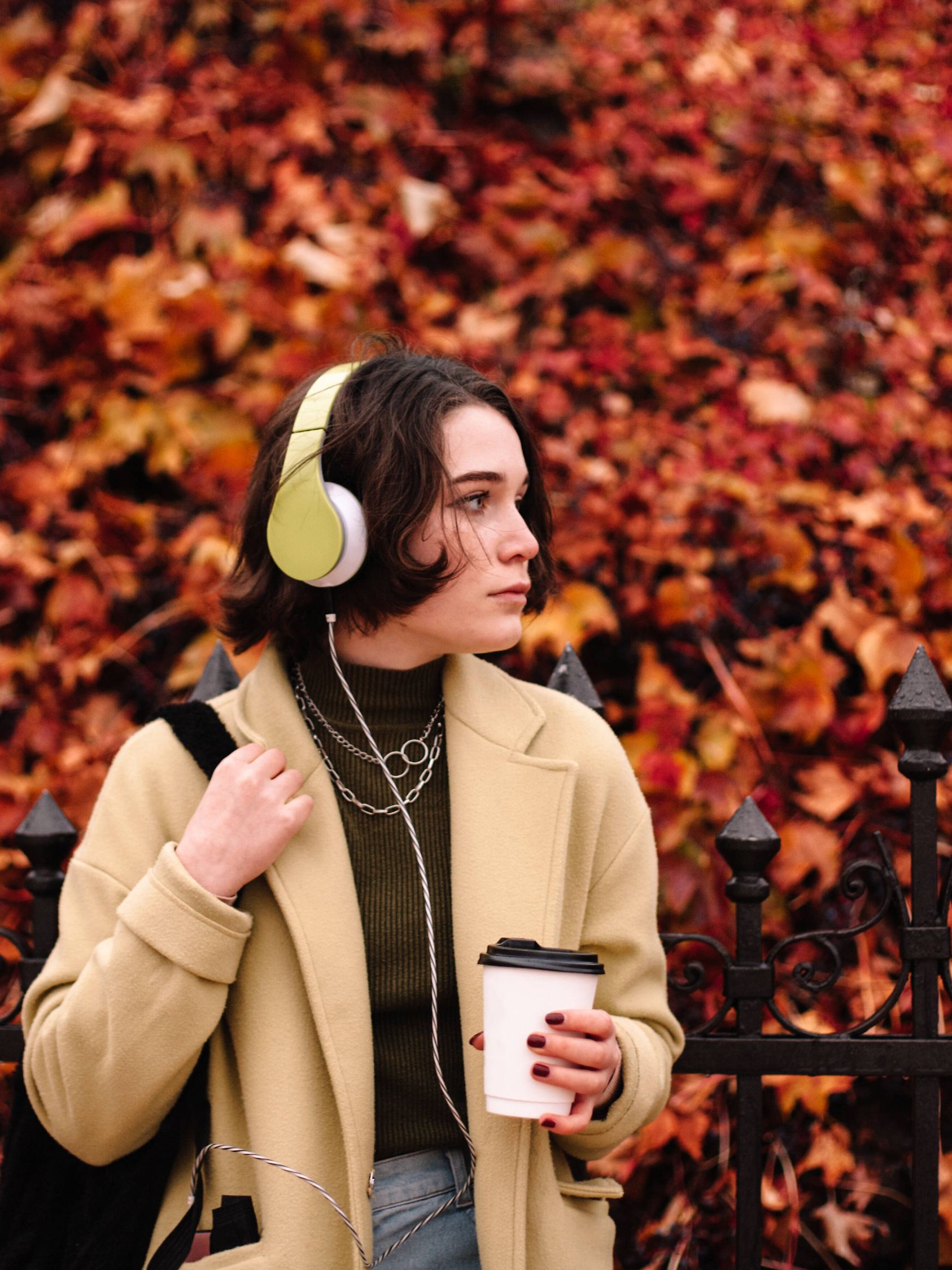 Eine Frau im Mantel in einem Herbstoutfit. 