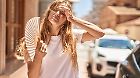Young blonde girl using handfan at street