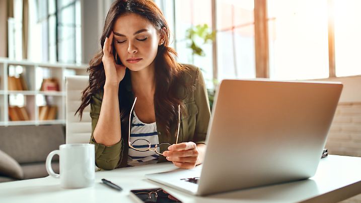 Müde, gestresste Frau im Homeoffice arbeiten