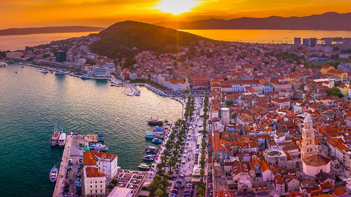 Panoramic view of Split, Croatia, showcasing its historic Old Town, and Adriatic coastline bathed in the warm hues of a stunning sunset, capturing the charm of this Dalmatian city