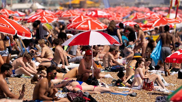 FILE PHOTO: Beachgoers enjoy the seaside during warm weather as temperatures rise across the UK, in Brighton