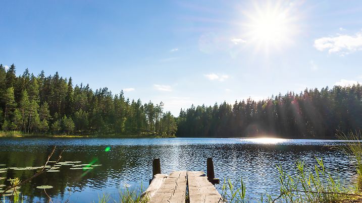 Schöner See an einem Sommertag und ein altes rustikales Pier in Finnland