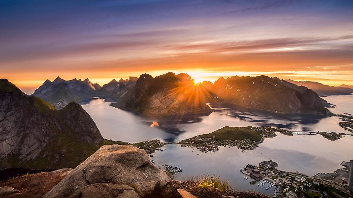 Mitternachtssonne vom Reinebringen über dem Küstenort Reine auf den Lofoten-Inseln im Norden von Norwegen.
