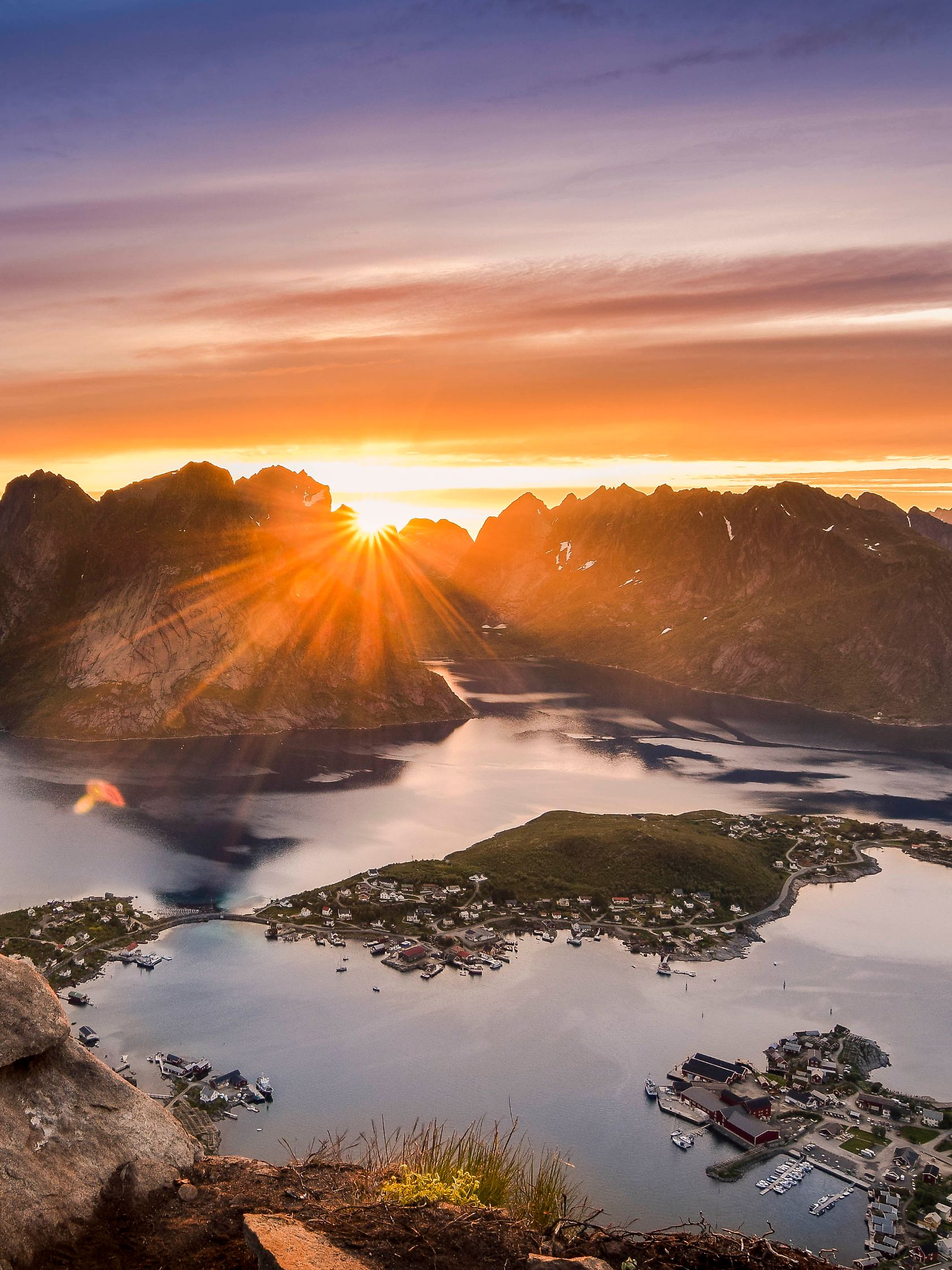 Mitternachtssonne vom Reinebringen über dem Küstenort Reine auf den Lofoten-Inseln im Norden von Norwegen.