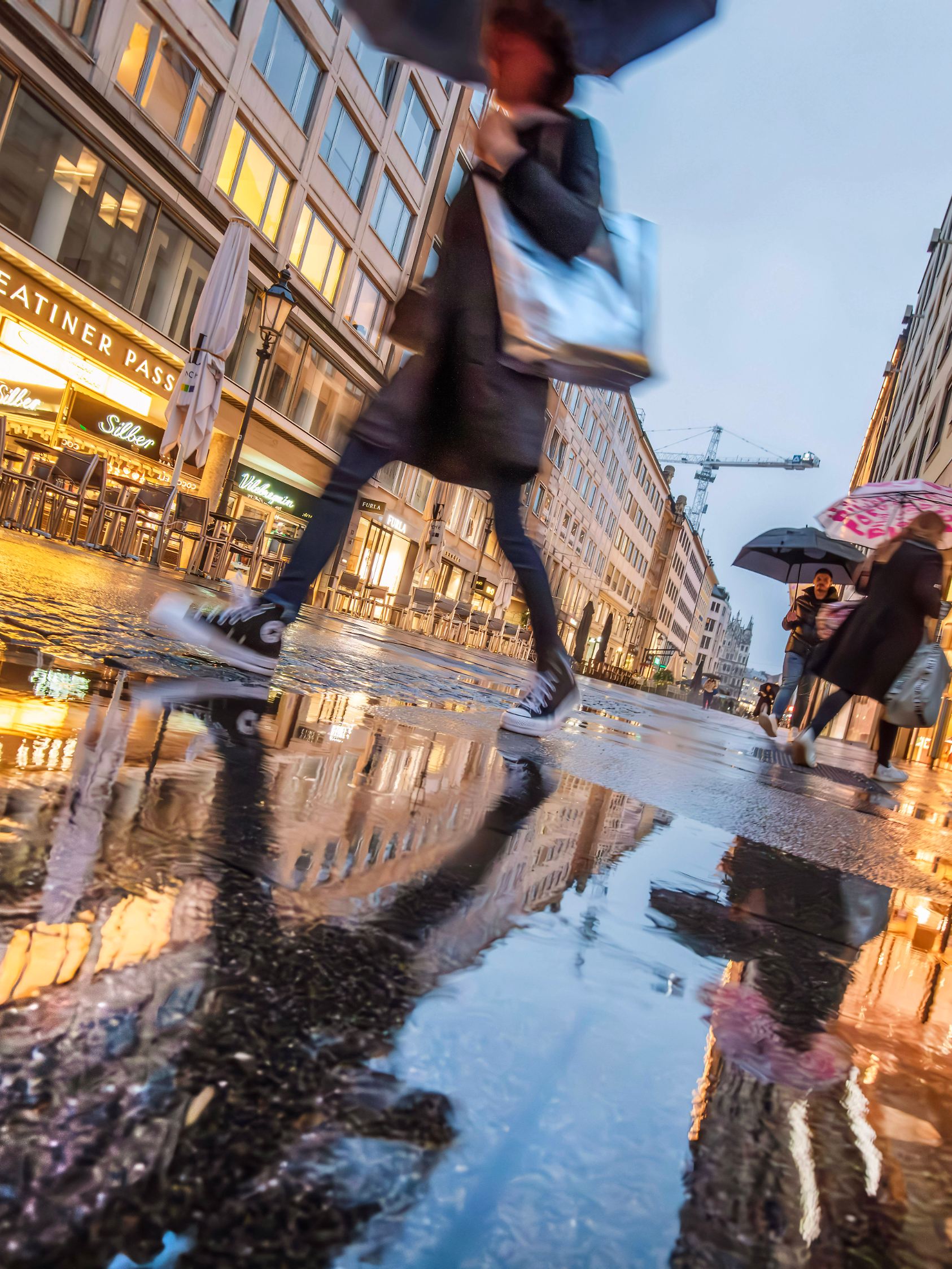Theatinerstrasse im Dauerregen, nur wenige Kunden abends in der Einkaufsstraße unterwegs, München, September 2024 Deutsc