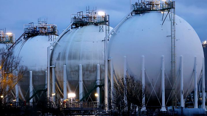 Gasspeicher mit ihrer typischen runden Form stehen in Industrieanlagen in Köln Godorf. Die Umgebung ist geprägt von Stro
