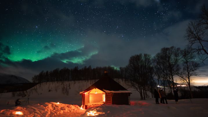 So schön leuchten die Polarlichter im verschneiten Tromso in Norwegen.