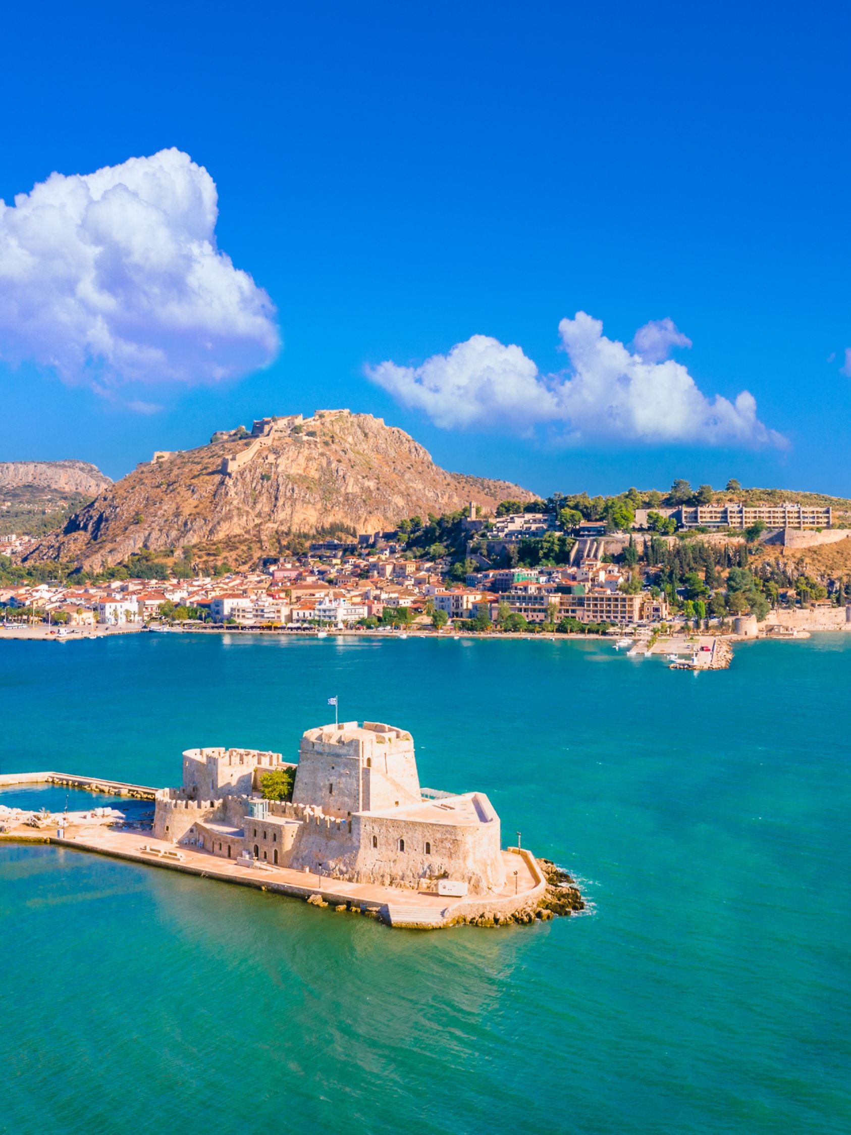 The old town of Nafplio in Greece with tiled roofs, small port, bourtzi castle, Palamidi fortress