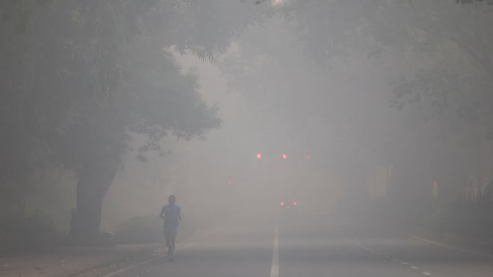 A man jogs on a road shrouded in smog on the day after Diwali, in New Delhi