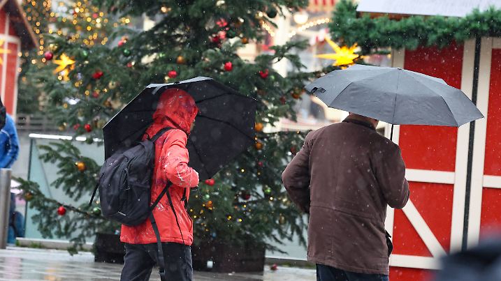 P12 VB K+ Menschen mit Schirm auf dem Weihnachtsmarkt