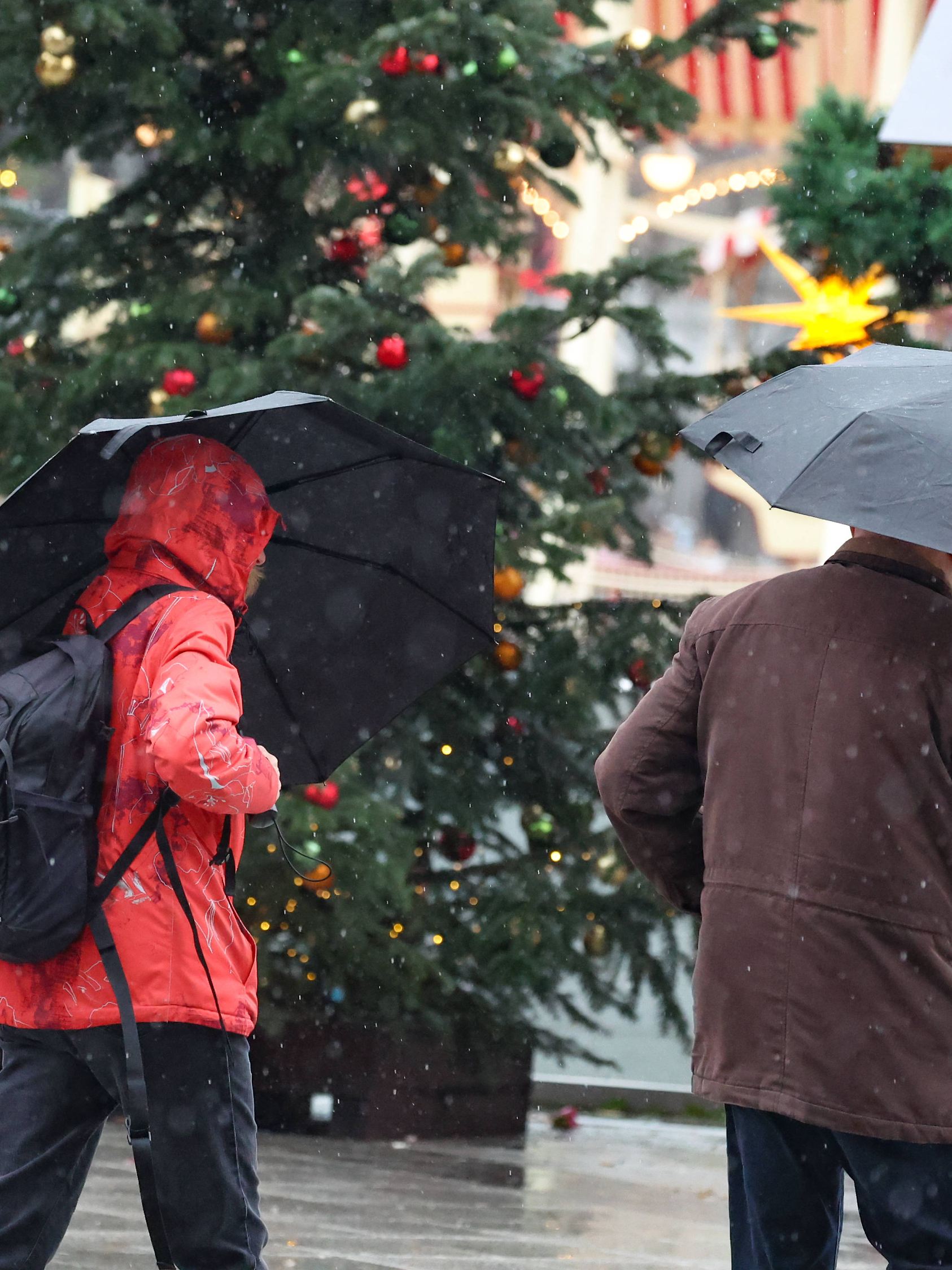 P12 VB K+ Menschen mit Schirm auf dem Weihnachtsmarkt