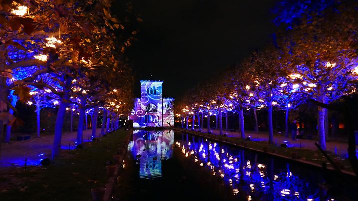 Stuttgart, Germany - November 19, 2019: Christmas decor of Christmas Garden Stuttgart. New Year and winter holiday celebration traditions. Illuminated building of zoological and botanical garden Wilhelma. Blurry shiny lights in darkness of night.