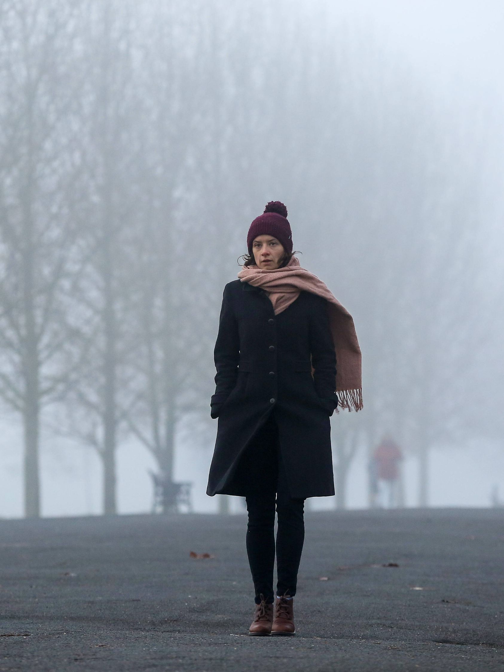 November 27, 2020, London, United Kingdom: A woman wrapped up warm walk on the street on a foggy and cold morning in Lon