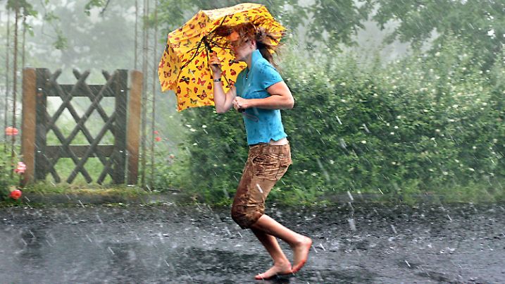 Ein junges Mädchen rennt am Samstag (09.06.2007) in Arnsberg durch ein Unwetter mit starkem Platzregen und Hagel. Bei kräftigen Unwettern über dem Westen und Südwesten Deutschlands sind 14 Menschen durch Blitzschlag verletzt worden. Überflutete Straßen behinderten in Nordrhein-Westfalen, Baden-Württemberg, Hessen und Rheinland-Pfalz den Verkehr. Foto: Julian Stratenschulte dpa/lnw +++(c) dpa - Bildfunk+++