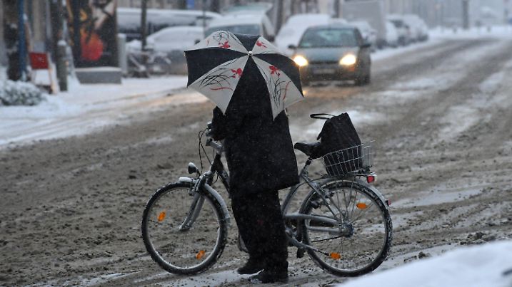 Eine Frau schiebt am Montagmorgen (29.11.2010) ihr Fahrrad über eine verschneite Kreuzung in der bayerischen Landeshauptstadt München (Oberbayern). Mit mehreren Zentimetern Neuschnee hat in der vergangenen Nacht der Winter in weiten Teilen Bayerns Einzug gehalten. Foto Peter Kneffel dpa/lby +++(c) dpa - Bildfunk+++
