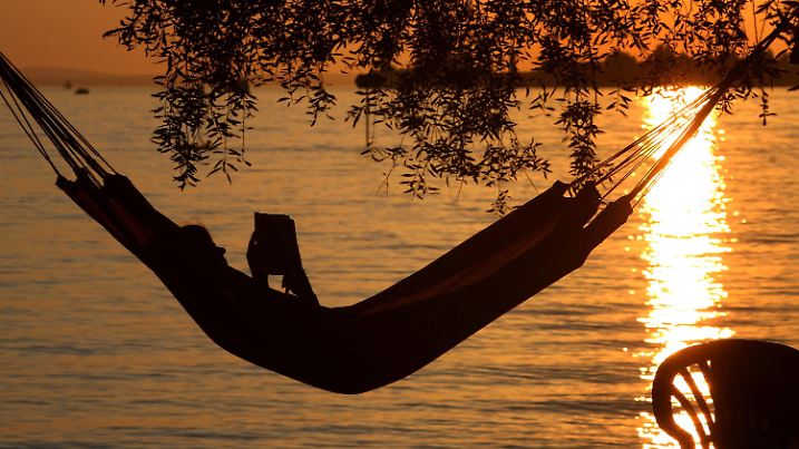 Eine Frau liest am Samstag (20.08.2011) in einer Hängematte am Badestrand eines Campingplatzes in Lindau (Schwaben) ein Buch. Ideales Strand- und Badewetter herrscht derzeit am Bodensee. Die Temperaturen steigen bis auf 32 Grad. Foto: Karl-Josef Hildenbrand dpa/lby/lsw  +++(c) dpa - Bildfunk+++