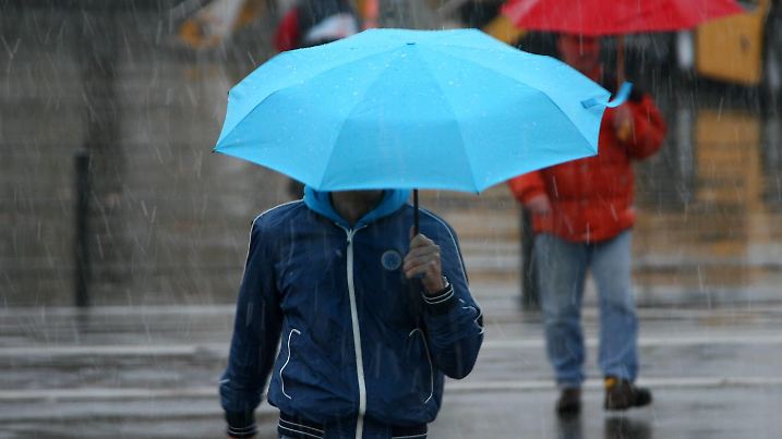 Von den ersten Schneefällen der Saison werden am Mittwoch (04.11.2009) Passanten in Kiel befeuchtet. Die Mischung aus Schnee, Graupel und Regen sorgte bei teilweise heftigem Wind und Temperaturen zwischen zwei und sechs Grad für ungemütliches Novemberwetter. Foto: Carsten Rehder dpa/lno +++(c) dpa - Bildfunk+++
